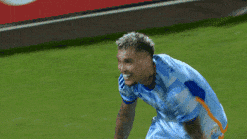 a soccer player wearing a light blue jersey with the word adidas on the front