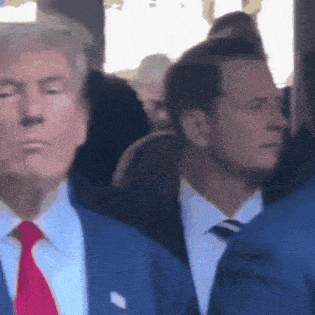 a man in a suit and tie is standing in a crowd