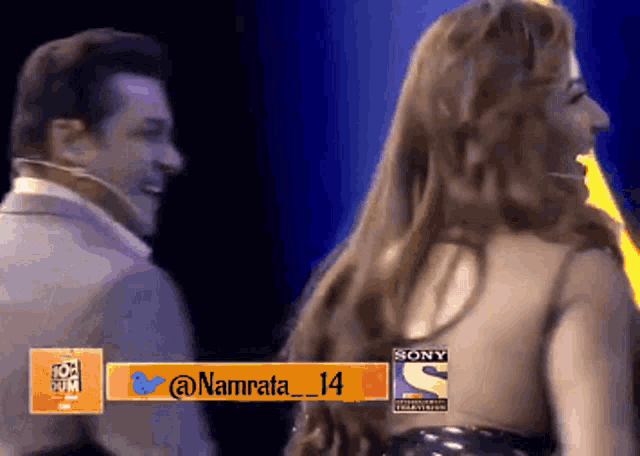 a man and a woman are dancing in front of a screen that says sony