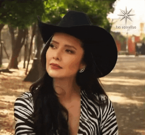 a woman wearing a cowboy hat and a zebra print jacket