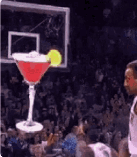 a martini is being dunked into a basketball hoop by a basketball player