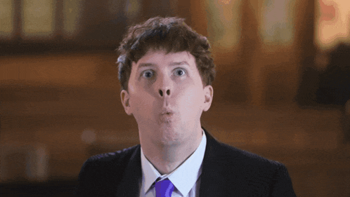 a man in a suit and tie making a face