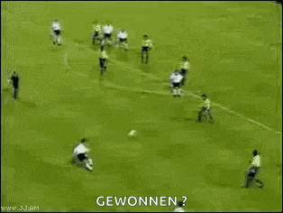 a soccer goalie is trying to stop a soccer ball from going in the goal .