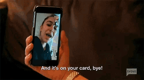 a woman is holding a cell phone in her hand and taking a picture of a girl .