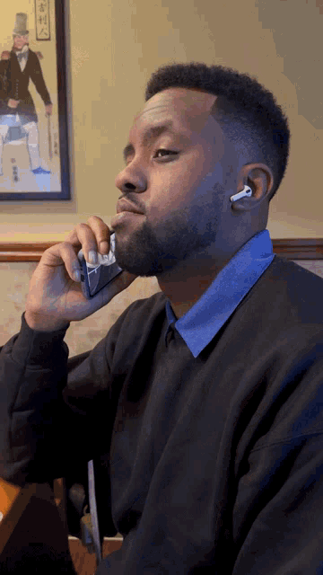 a man wearing ear buds is talking on a cell phone