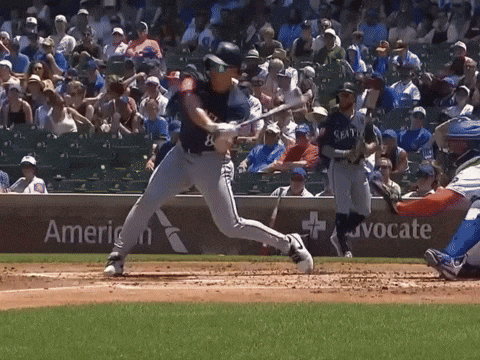 a baseball player swings his bat at a ball in front of an american advocate sign