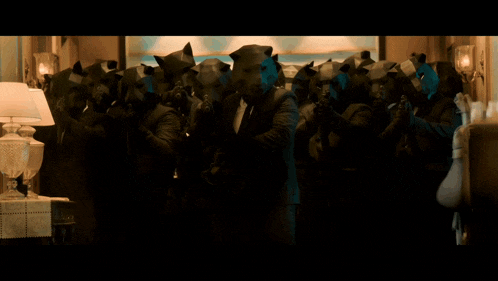 a blurred image of a crowd of people standing in a dark room