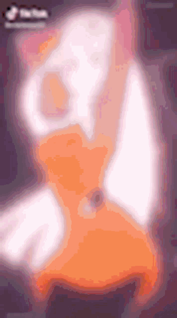 a blurred image of a cat in an orange dress on a black background .