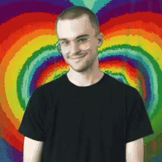 a man in a black shirt stands in front of a colorful background