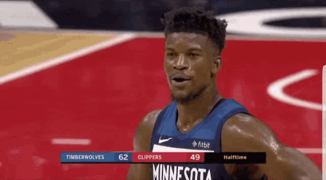 a basketball player from the minnesota timberwolves is standing on the court during a game .