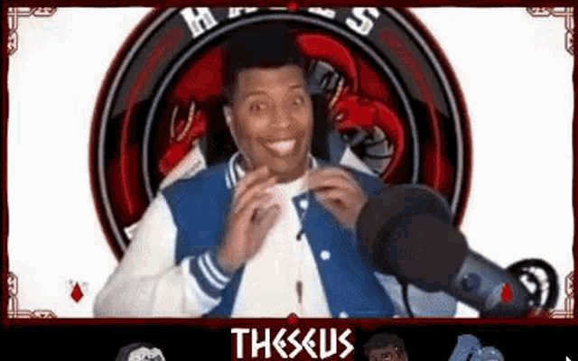 a man in a varsity jacket is standing in front of a microphone .