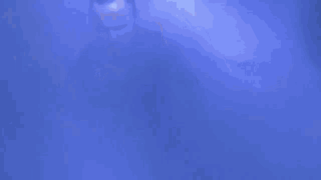 a man with a beard is standing in a dark room with smoke coming out of his mouth .