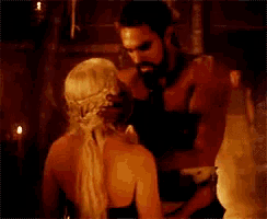 a man and a woman are dancing in a dark room with candles .