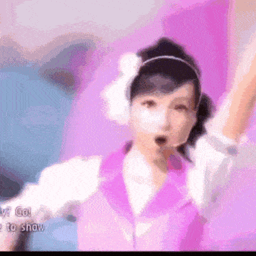 a woman in a purple and white outfit is holding her arms up in the air
