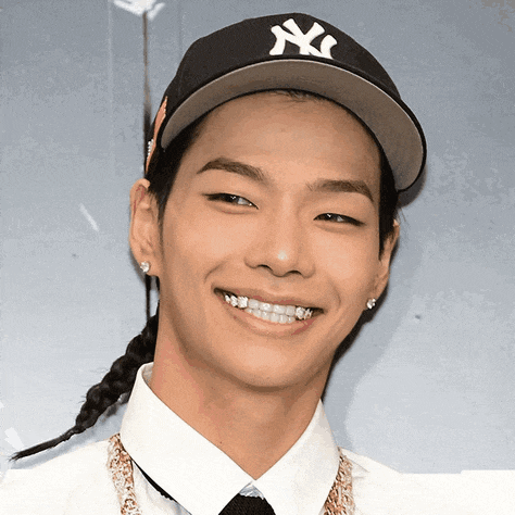 a young man wearing a ny yankees hat smiles