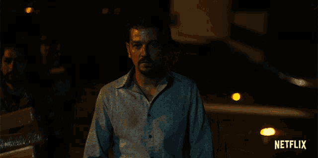 a man in a blue shirt with a netflix logo on the bottom right