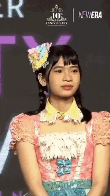 a girl is wearing a pink dress and a yellow collar