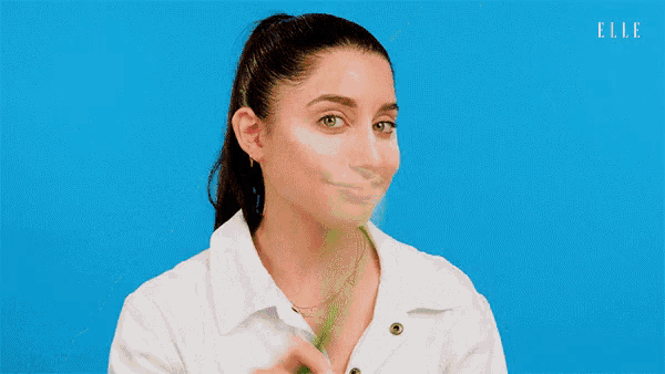 a woman is brushing her teeth with a toothbrush and making a funny face .