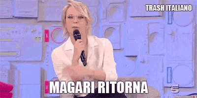 a woman is sitting in front of a microphone and says " magari ritorna " .