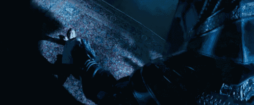 a man in a blue suit is standing in the dark