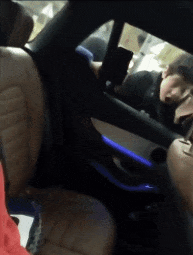 a person sitting in a car with a phone in their hand