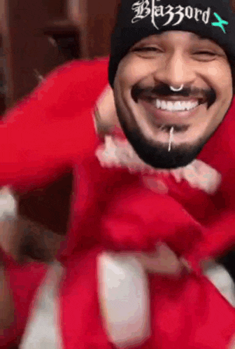 a man with a beard wearing a black beanie with the word blazzard on it