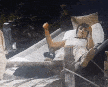 a person is laying on a bed with their arm up