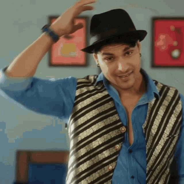 a man wearing a hat and a vest is smiling