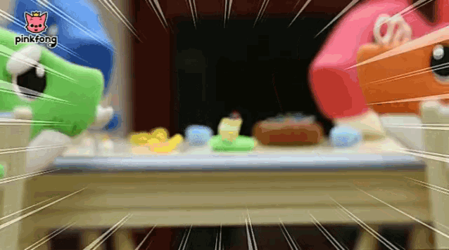two stuffed animals are sitting at a table with a pinkfang logo in the corner