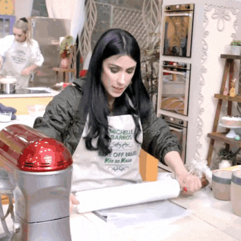 a woman wearing an apron that says michelle barros is rolling dough