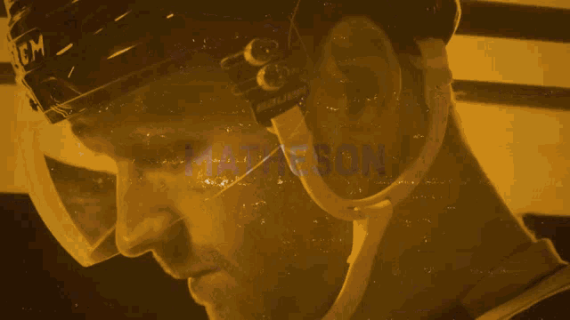 a close up of a hockey player 's face with the number 20 behind him