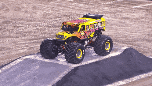 a monster truck that looks like a school bus is driving down a dirt track