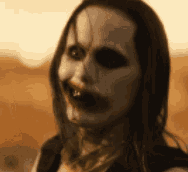 a close up of a woman 's face with a bloody mouth and a scary face .
