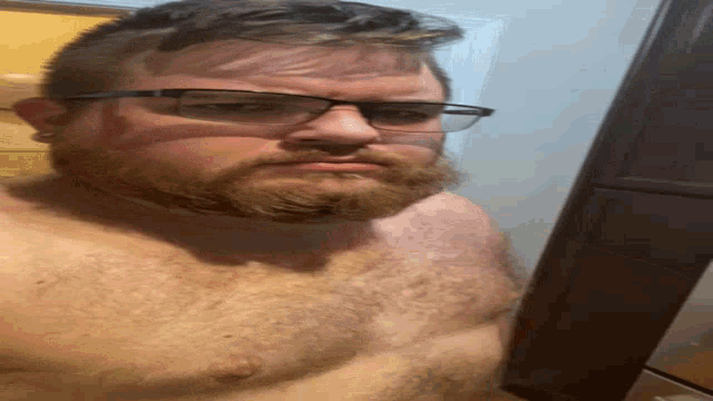 a shirtless man with a beard wearing sunglasses