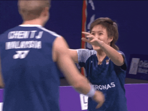 a person wearing a blue jersey that says petronas on the front