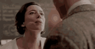 a man and a woman are looking at each other . the woman has a scar on her face .