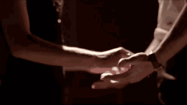a man and a woman hold hands in a dark room