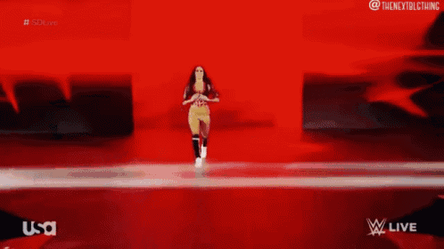 a woman is walking on a red and white striped runway .