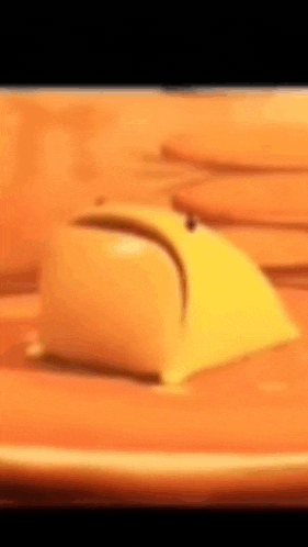 a close up of a yellow mouse sitting on a table .