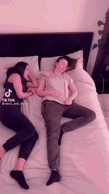 two women laying on a bed with tiktok written on the bottom left