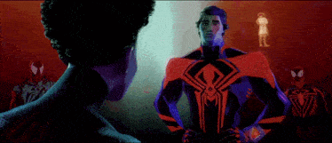 a man in a spiderman suit is standing next to a woman