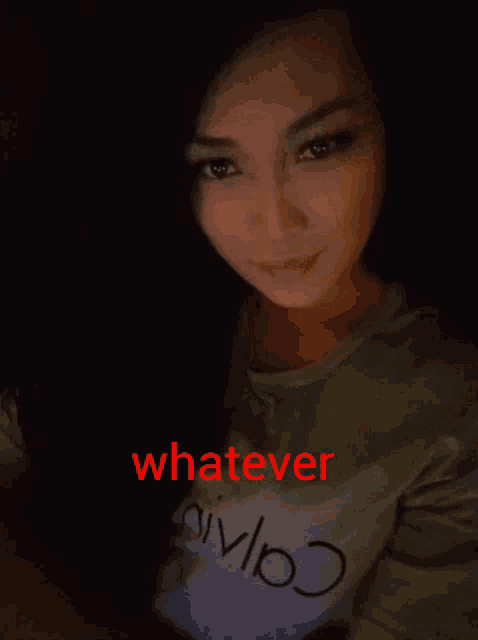 a woman wearing a shirt that says whatever is smiling