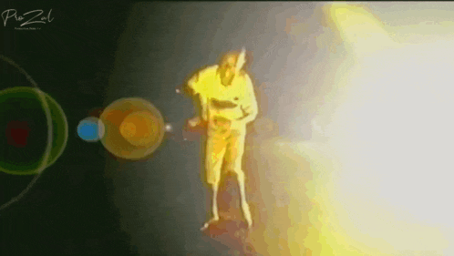 a man in a yellow shirt is dancing on a stage