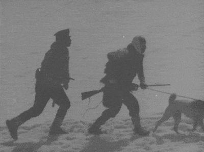 a black and white photo of a man with a gun and a dog