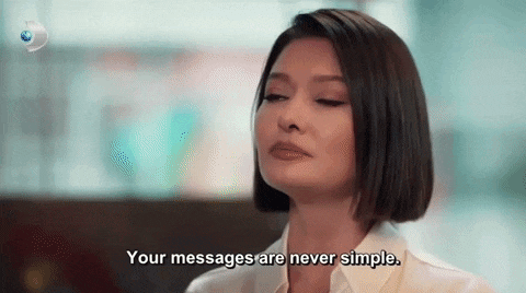 a woman is sitting at a table with her eyes closed and saying `` your messages are never simple '' .