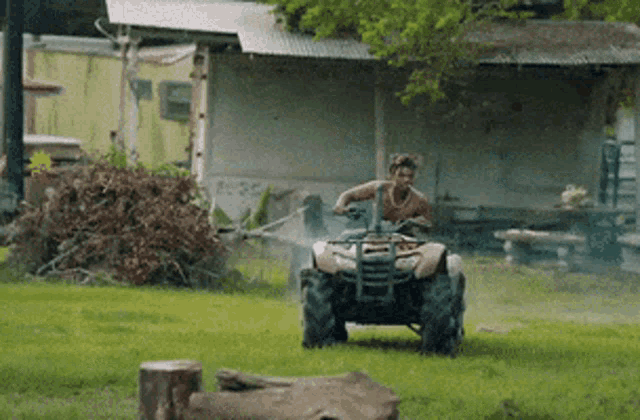 a man is driving an atv in a grassy area