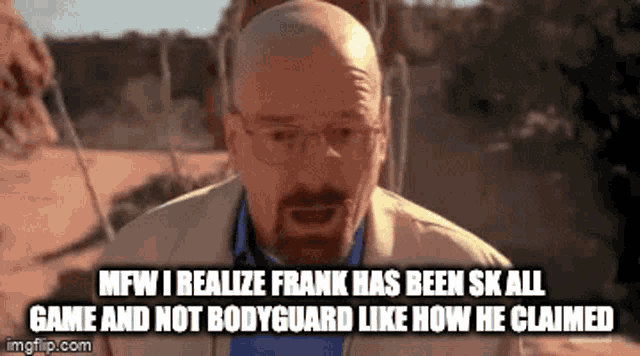 a bald man with glasses and a beard is making a funny face while standing in the desert .