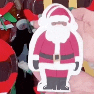 a person is holding a paper cut out of santa claus in their hand .