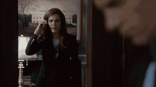 a woman in a black suit is standing next to a man in a suit in a room .