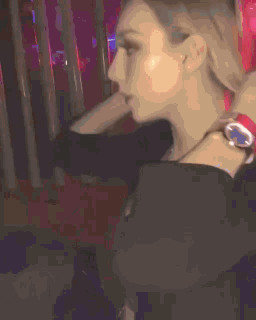 a woman wearing a watch and a black top is dancing